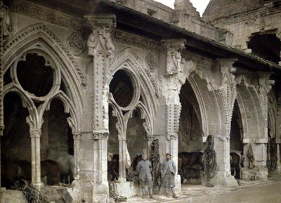 1917年，法国Aisne的Soissons遭到炮火严重破坏的Saint-Jean-des-Vignes修道院修道院内的两名法国士兵和马匹（自然色） 作者 费尔南德·库维尔
